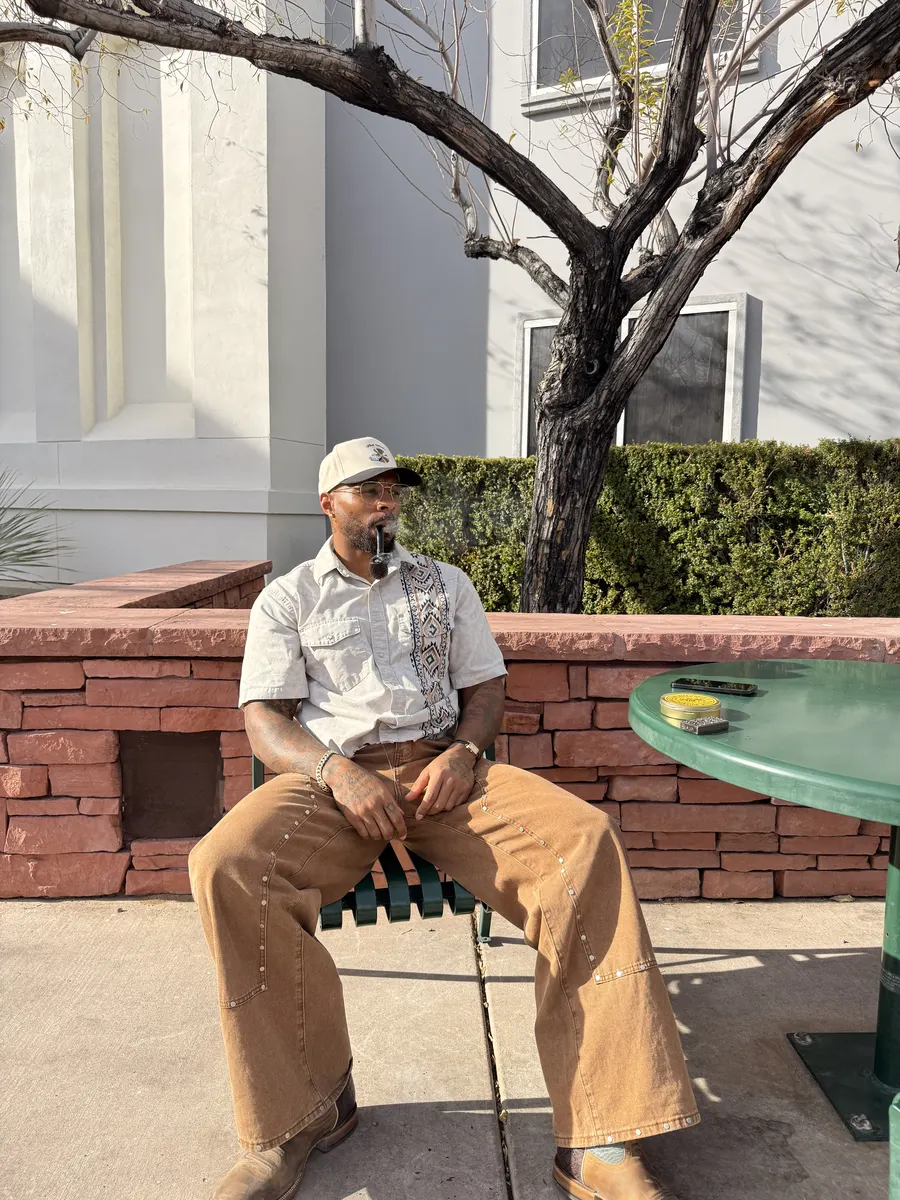 Anthony D. Martinez seated outdoors in Las Vegas sunlight, wearing a cap and glasses
